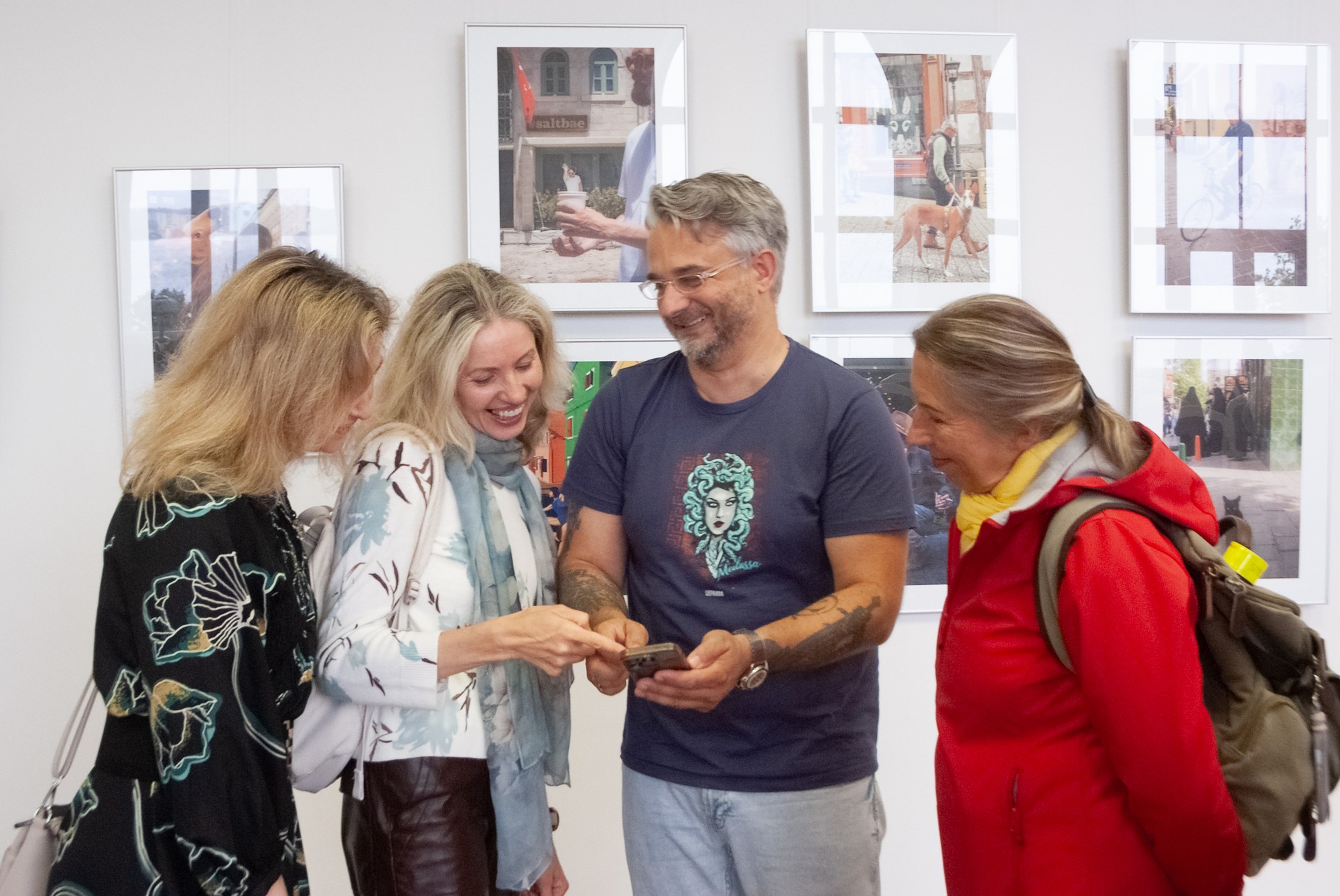 An artist and visitors discussing the exhibited photographs